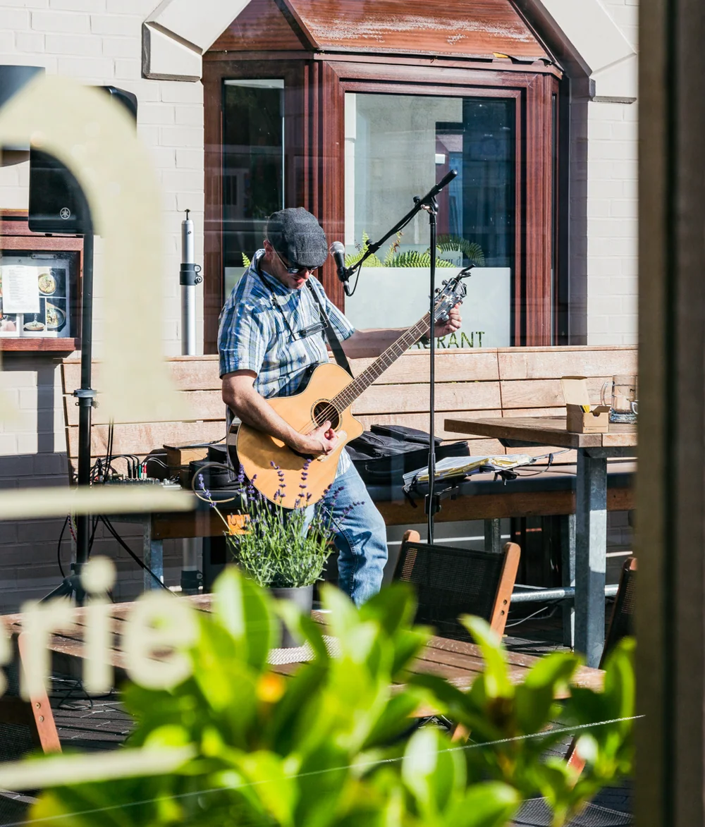 Live-Musiker mit Akustikgitarre auf der Terrasse des tween