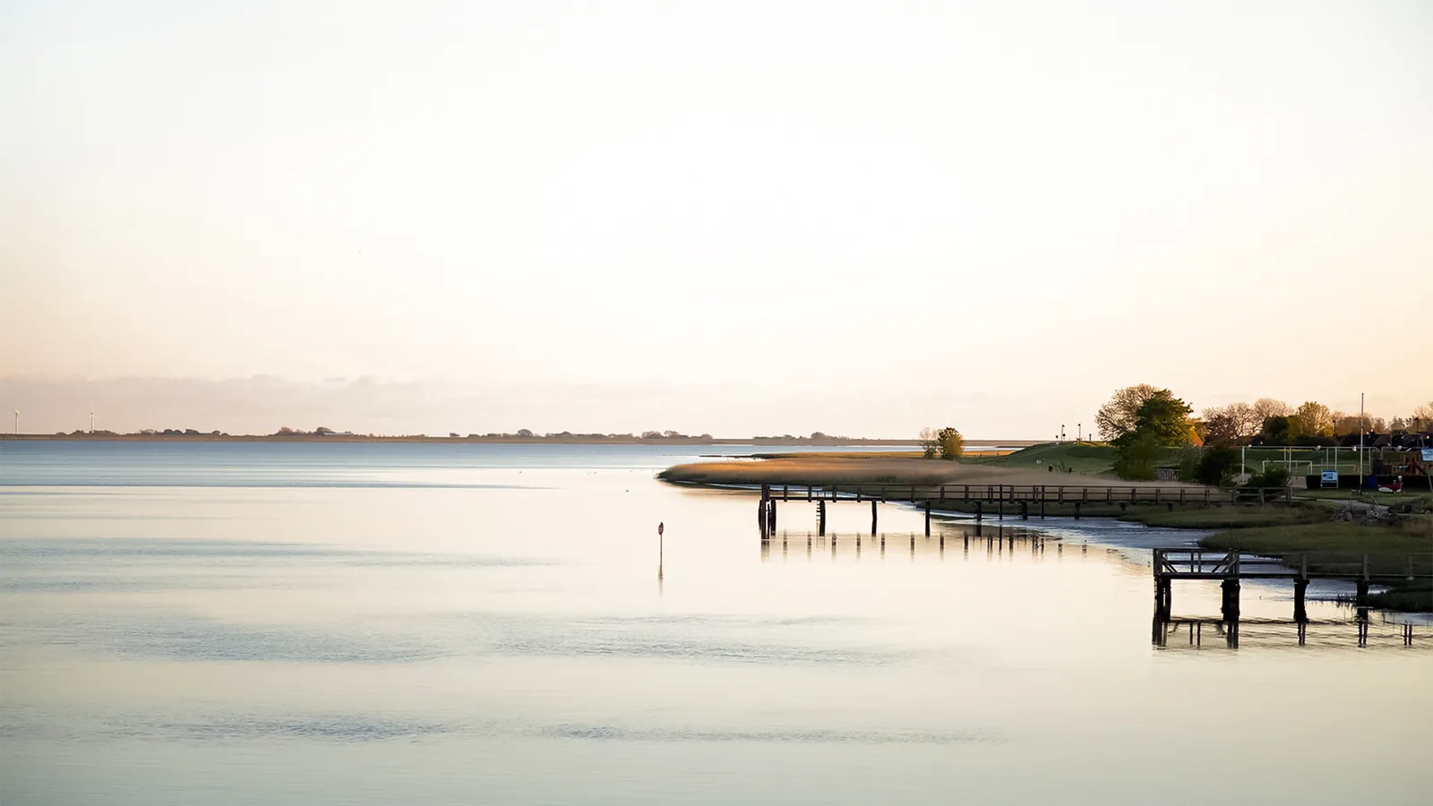 Ruhige Eiderlandschaft mit Steg und Ufer bei Abendlicht in Tönning